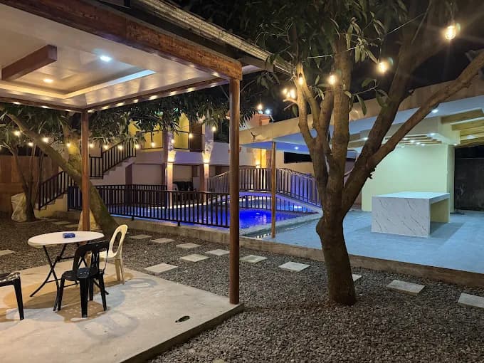 Dela Cruz Place Mini Resort at night - cabana, string lights, and glowing pool